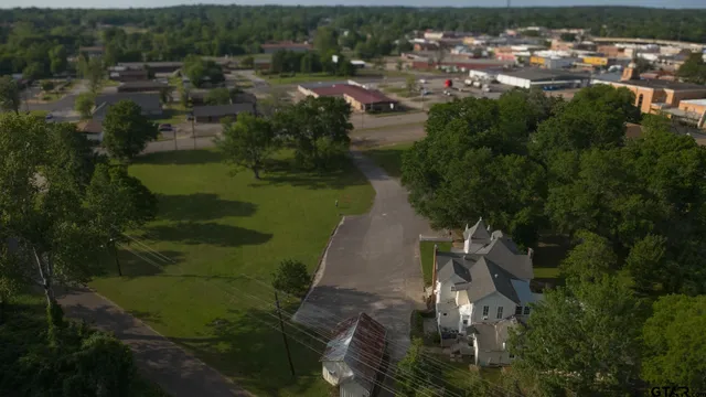 an aerial view of residential houses with outdoor space and trees