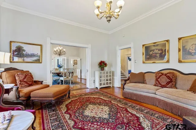 a view of a dining room with furniture a chandelier and wooden floor