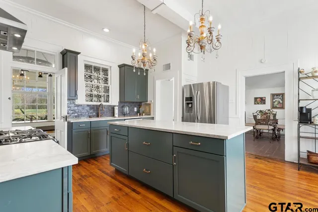 a kitchen with stainless steel appliances granite countertop a sink and a stove