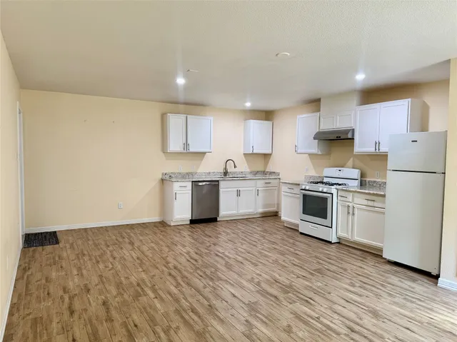 a kitchen with white cabinets and white appliances