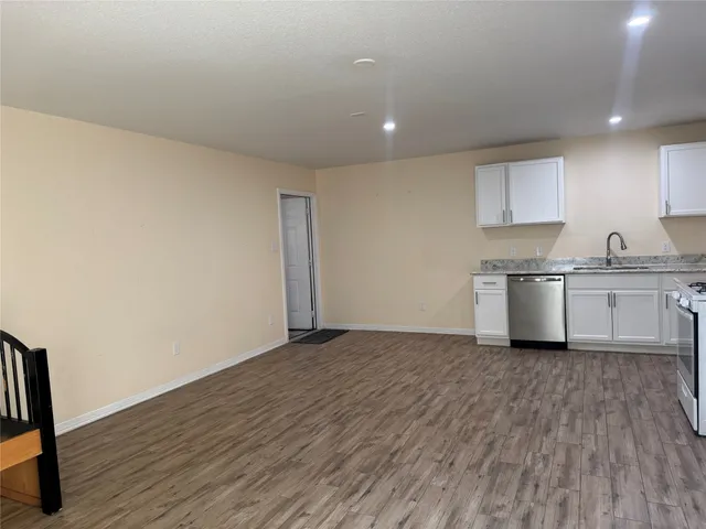 a view of a kitchen with a sink and wooden floor