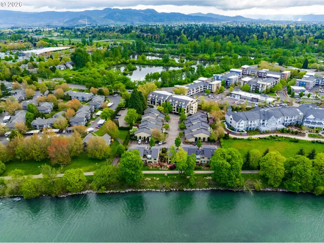 an aerial view of residential houses with outdoor space and lake view