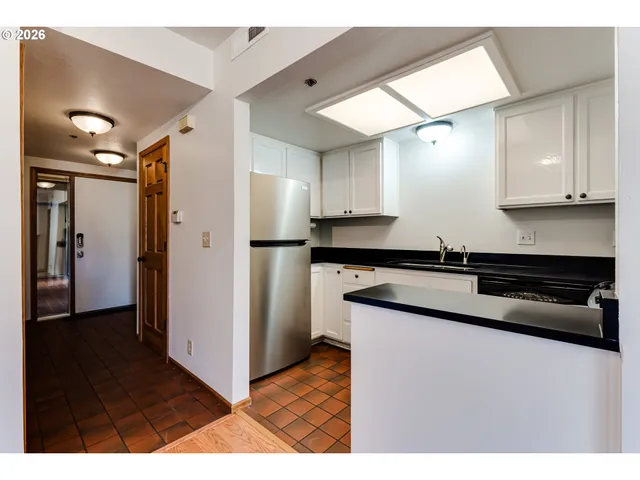 a kitchen with granite countertop a refrigerator and a sink