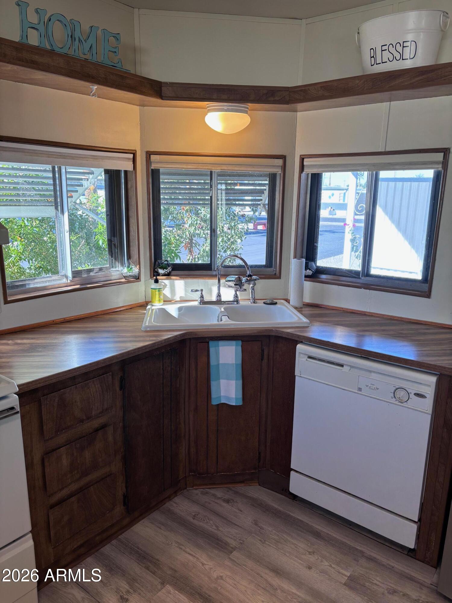 15802 South Gilbert Road, Unit 131 Chandler, AZ 85225 - Photo 3 of 30 a kitchen with granite countertop wooden cabinets a sink and a window