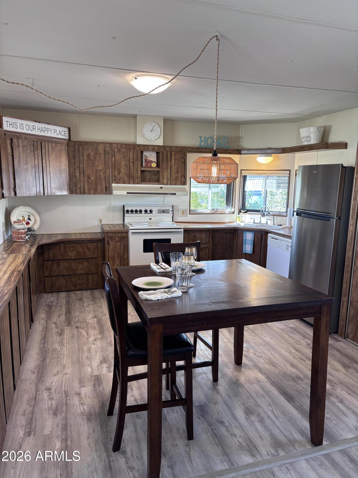 15802 South Gilbert Road, Unit 131 Chandler, AZ 85225 - Photo 5 of 30 a kitchen with a table chairs and a wooden floor