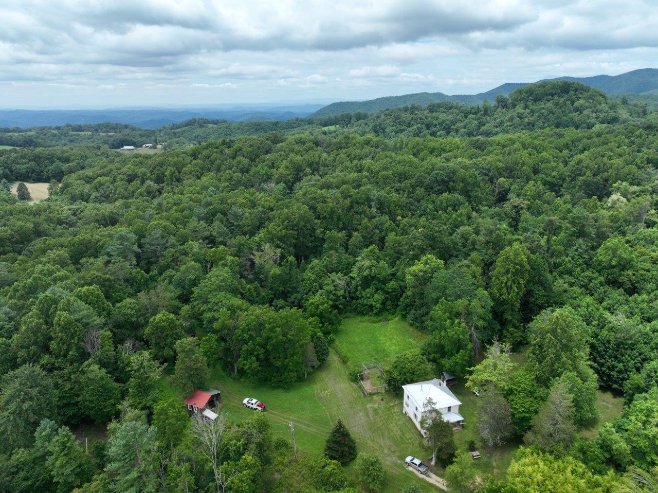 a backyard of a house with lots of green space and mountains