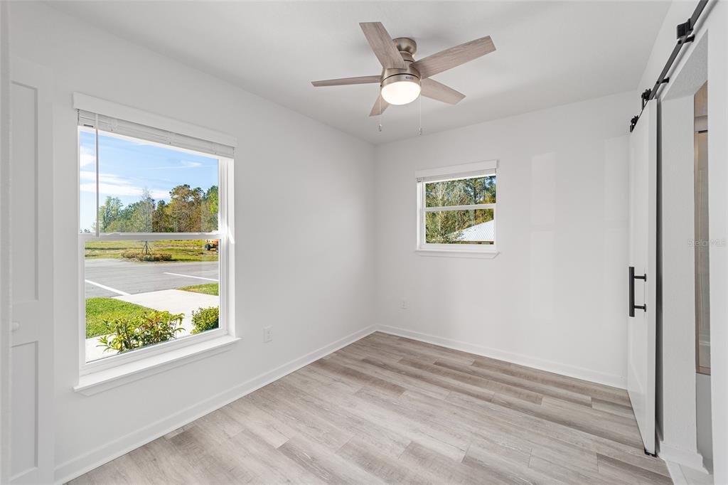 4417 Northwest 74th Terrace Ocala, FL 34482 - Photo 12 of 77 wooden floor in an empty room with a window