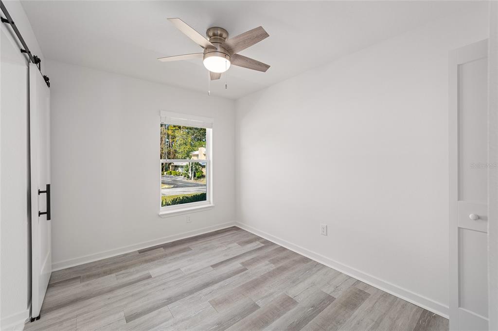 4417 Northwest 74th Terrace Ocala, FL 34482 - Photo 16 of 77 wooden floor in an empty room with a window