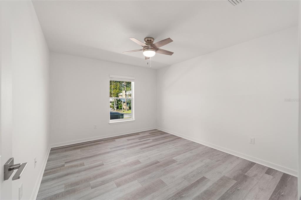 4417 Northwest 74th Terrace Ocala, FL 34482 - Photo 31 of 77 an empty room with wooden floor ceiling fan and windows