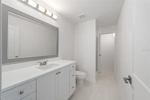 an empty room with wooden floor ceiling fan with window