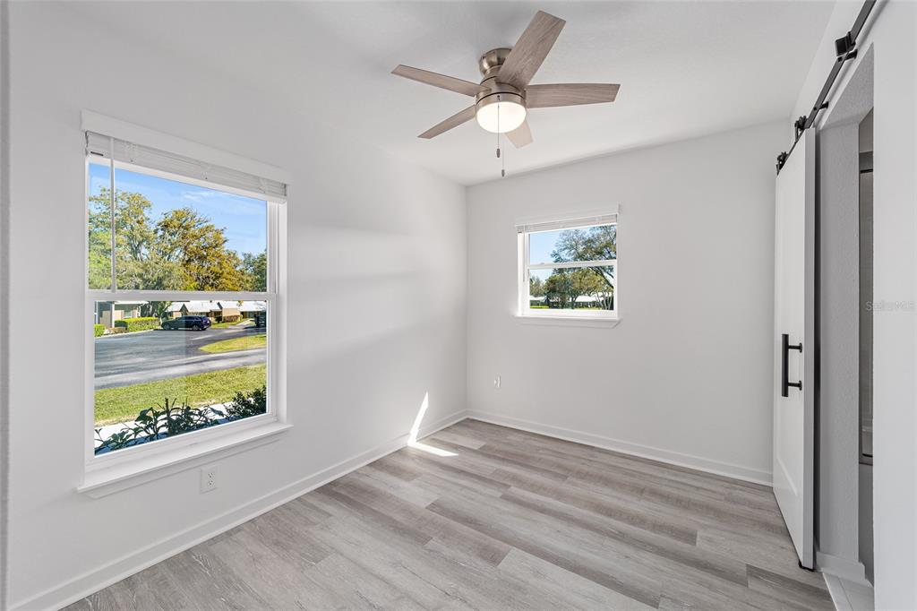 4417 Northwest 74th Terrace Ocala, FL 34482 - Photo 40 of 77 an empty room with wooden floor ceiling fan with window