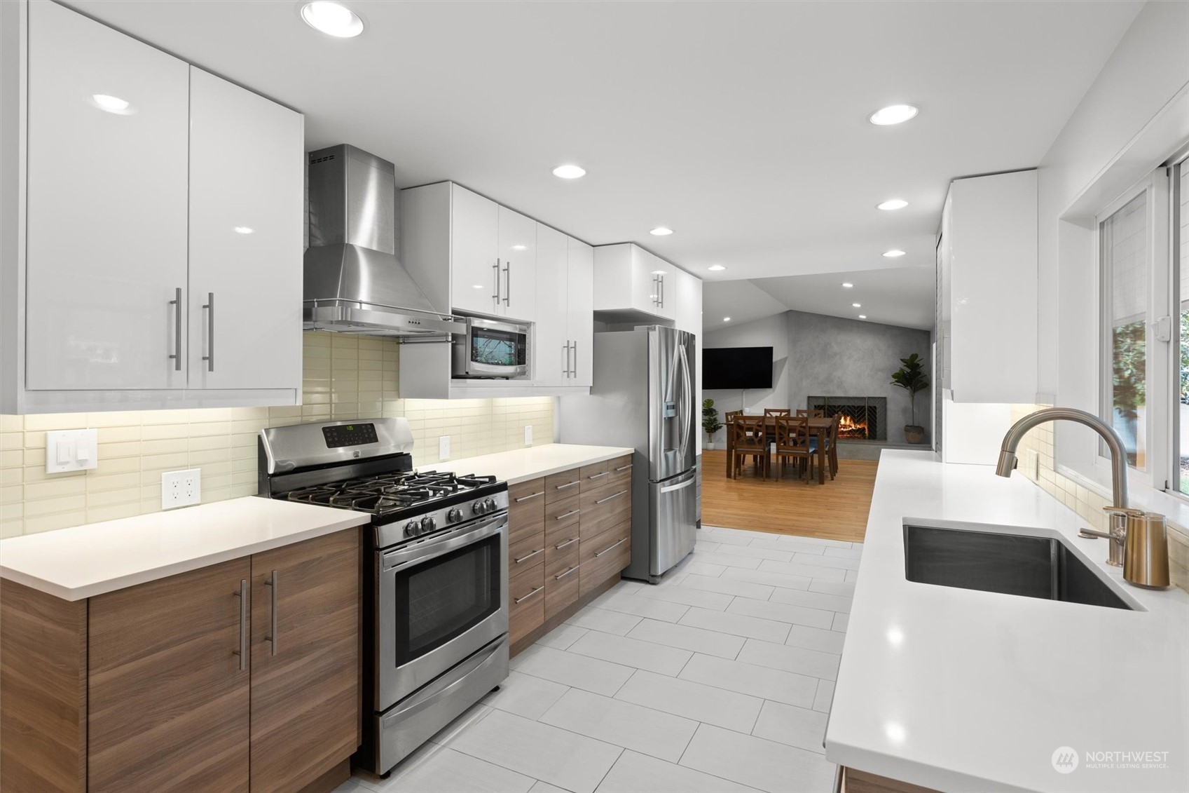 9631 Northeast 198th Street Bothell, WA 98011 - Photo 18 of 40 a kitchen with stainless steel appliances granite countertop a sink a stove a refrigerator cabinets and a dining table with wooden floor