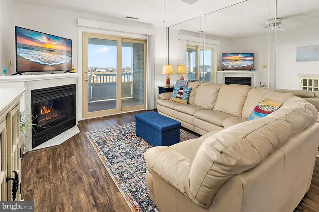 a living room with furniture large window and a fireplace