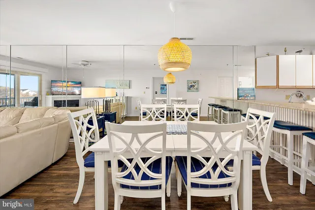 a kitchen with stainless steel appliances a stove a sink a refrigerator white cabinets and wooden floor