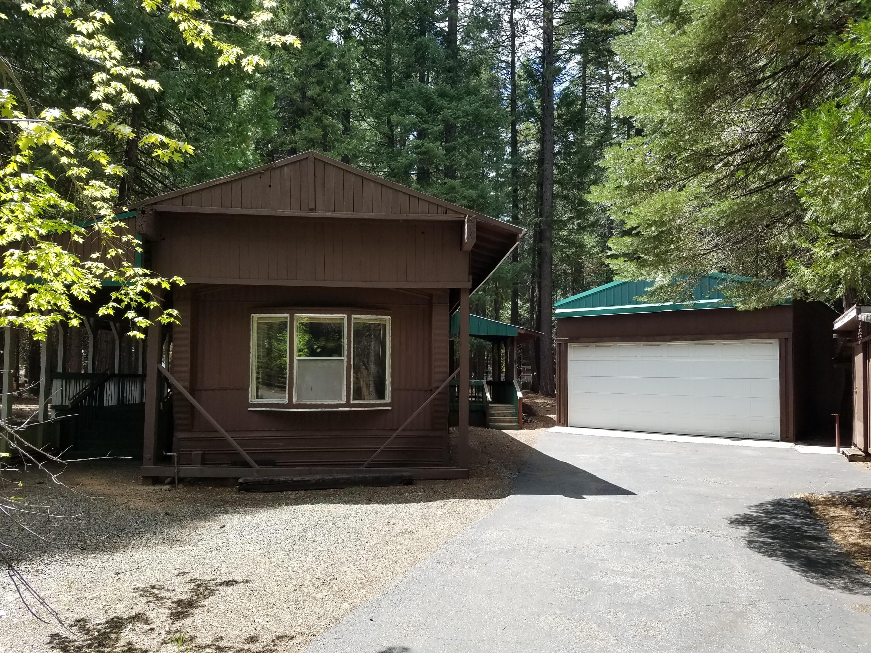 9340 Thatcher Mill Road Shingletown, CA 96088 - Photo 1 of 32 a front view of a house with a yard and garage