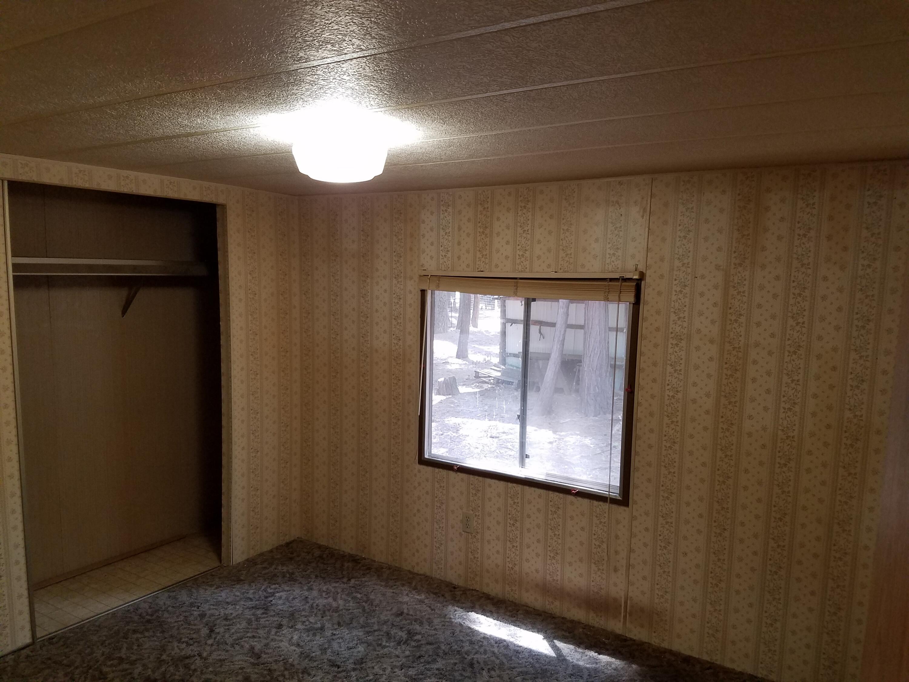 9340 Thatcher Mill Road Shingletown, CA 96088 - Photo 19 of 32 an empty room with wooden floor and windows