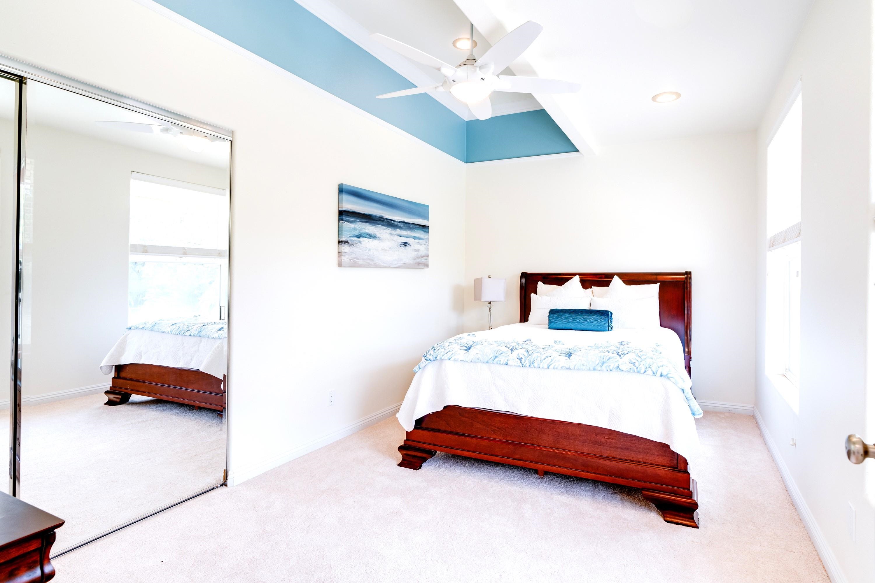 3446 Omaopio Road Kula, HI 96790 - Photo 37 of 49 a bedroom with a bed and a chandelier