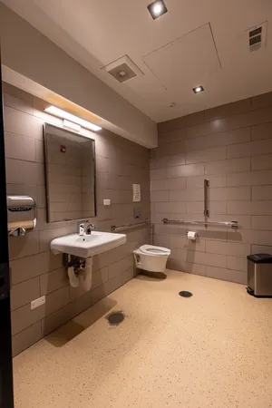 a kitchen with a sink a counter top space and living room view