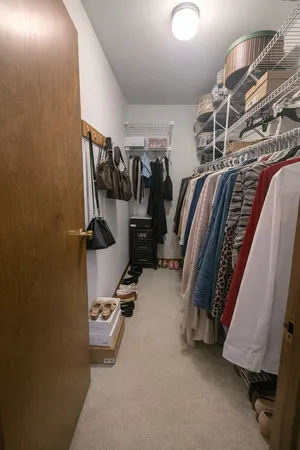a view of walk in closet with clothes and shoes