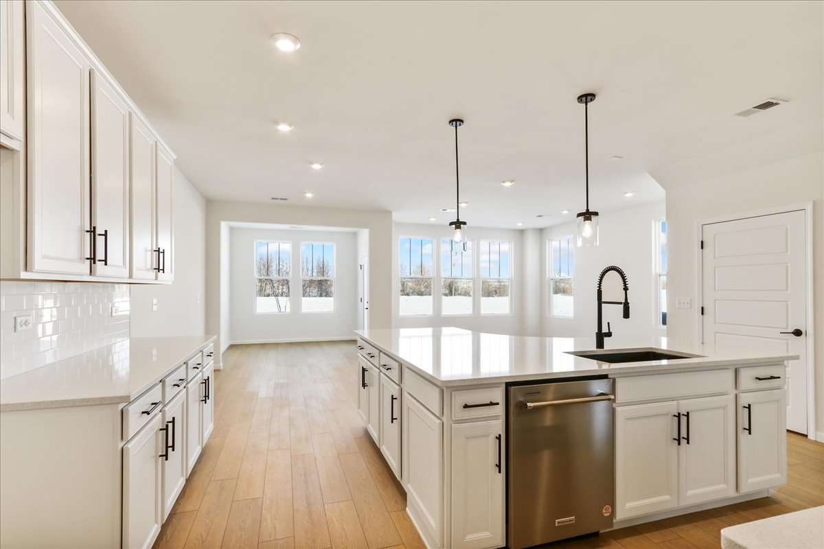 667 Switchgrass Way, Unit 62003 Bolingbrook, IL 60490 - Photo 12 of 33 a kitchen with stainless steel appliances granite countertop a sink a stove and a wooden floors