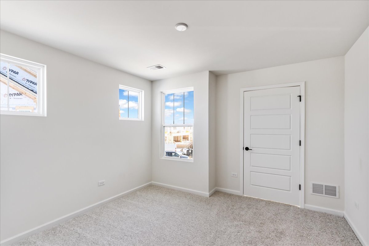 667 Switchgrass Way, Unit 62003 Bolingbrook, IL 60490 - Photo 26 of 33 an empty room with windows and closet