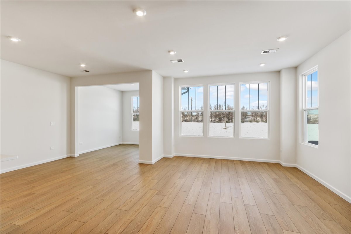 667 Switchgrass Way, Unit 62003 Bolingbrook, IL 60490 - Photo 5 of 33 a view of an empty room with wooden floor and a window