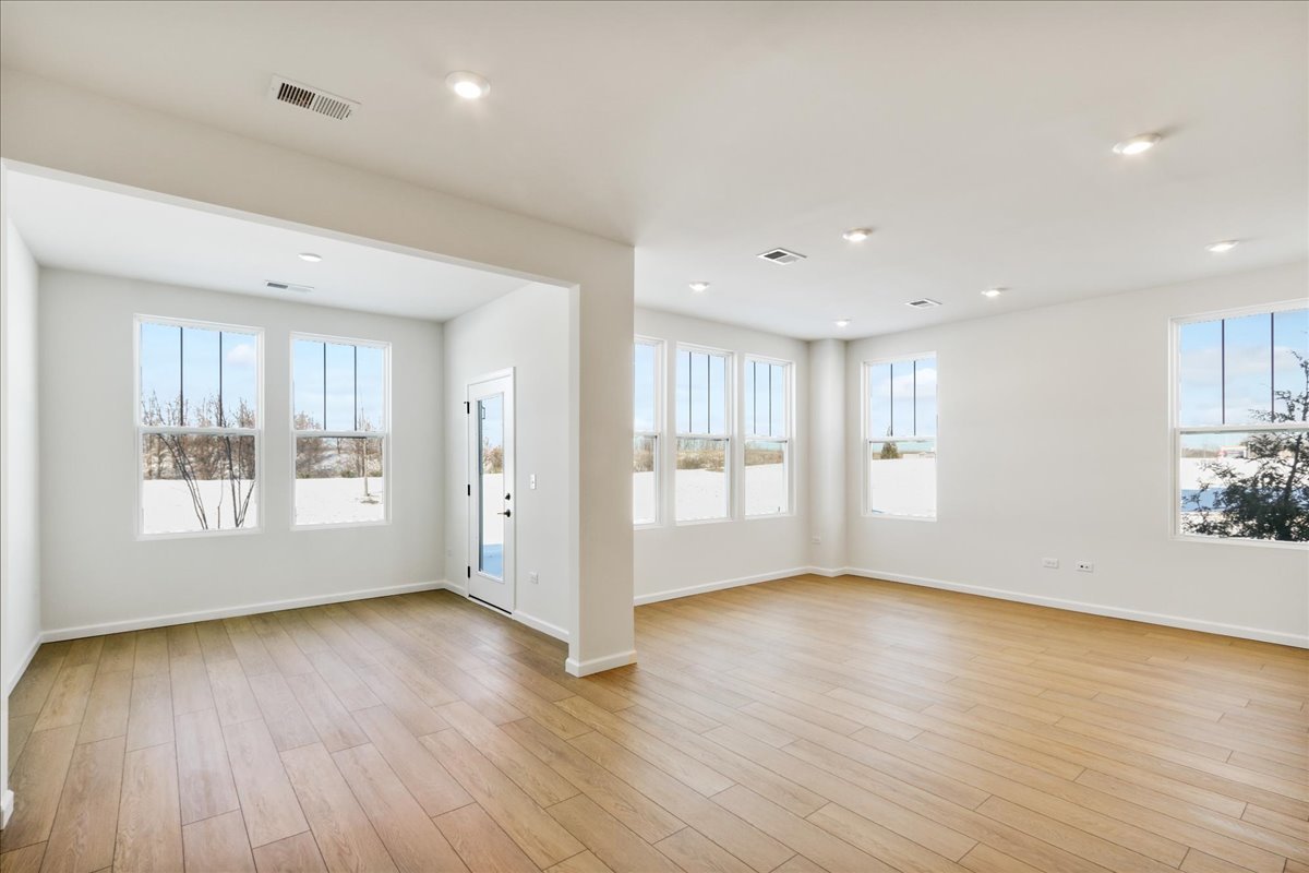667 Switchgrass Way, Unit 62003 Bolingbrook, IL 60490 - Photo 7 of 33 a view of an empty room with wooden floor and a window