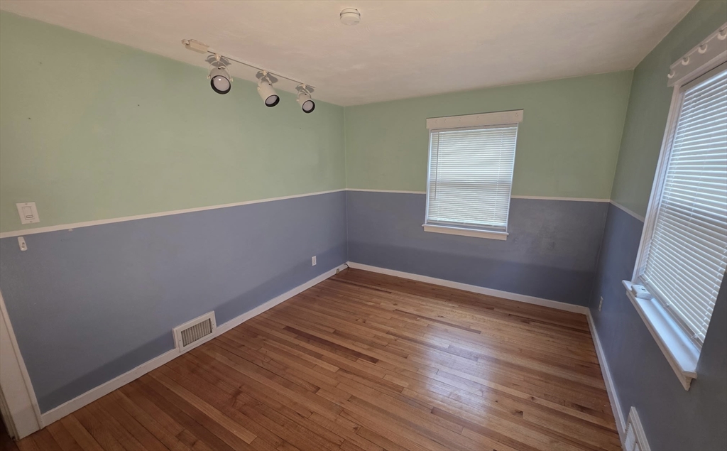 118 Spruce Road Norwood, MA 02062 - Photo 8 of 39 a view of an empty room with wooden floor and a window