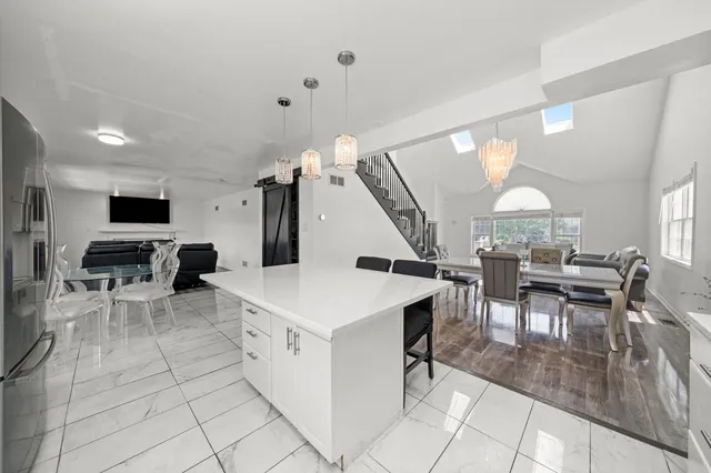 a large white kitchen with a table and chairs