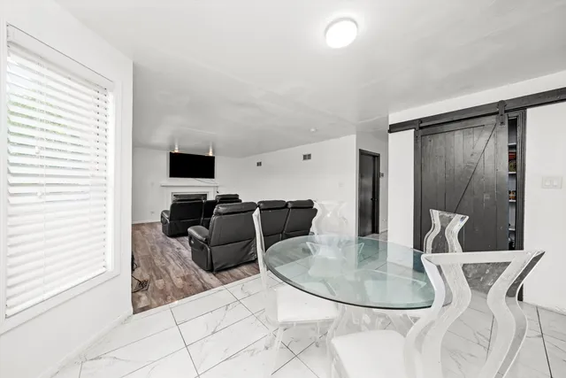 a living room with furniture a flat screen tv and a window