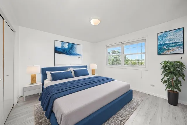 a bedroom with a large bed and a potted plant