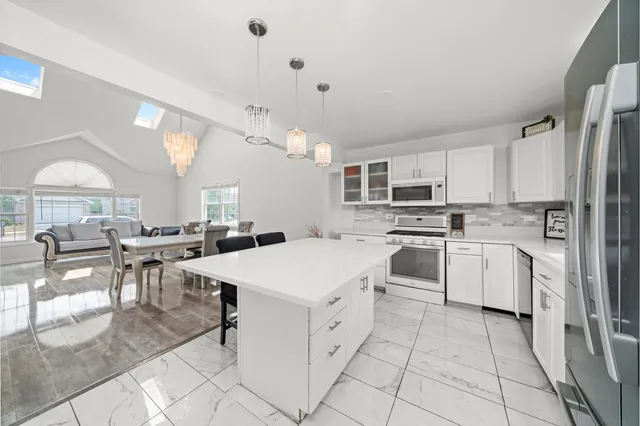 a kitchen with white cabinets and white appliances