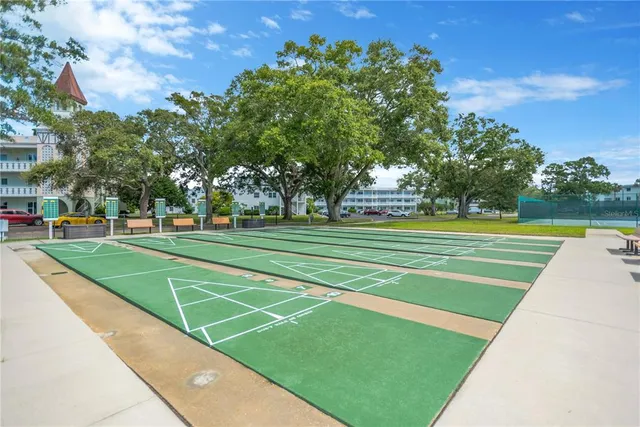 a view of a tennis ground with large trees