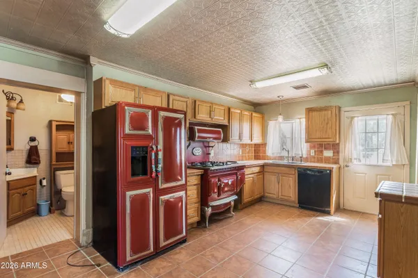 a large kitchen with stainless steel appliances granite countertop a refrigerator and stove