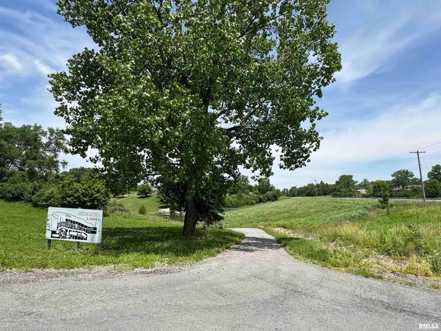 a sign board with a house in the background