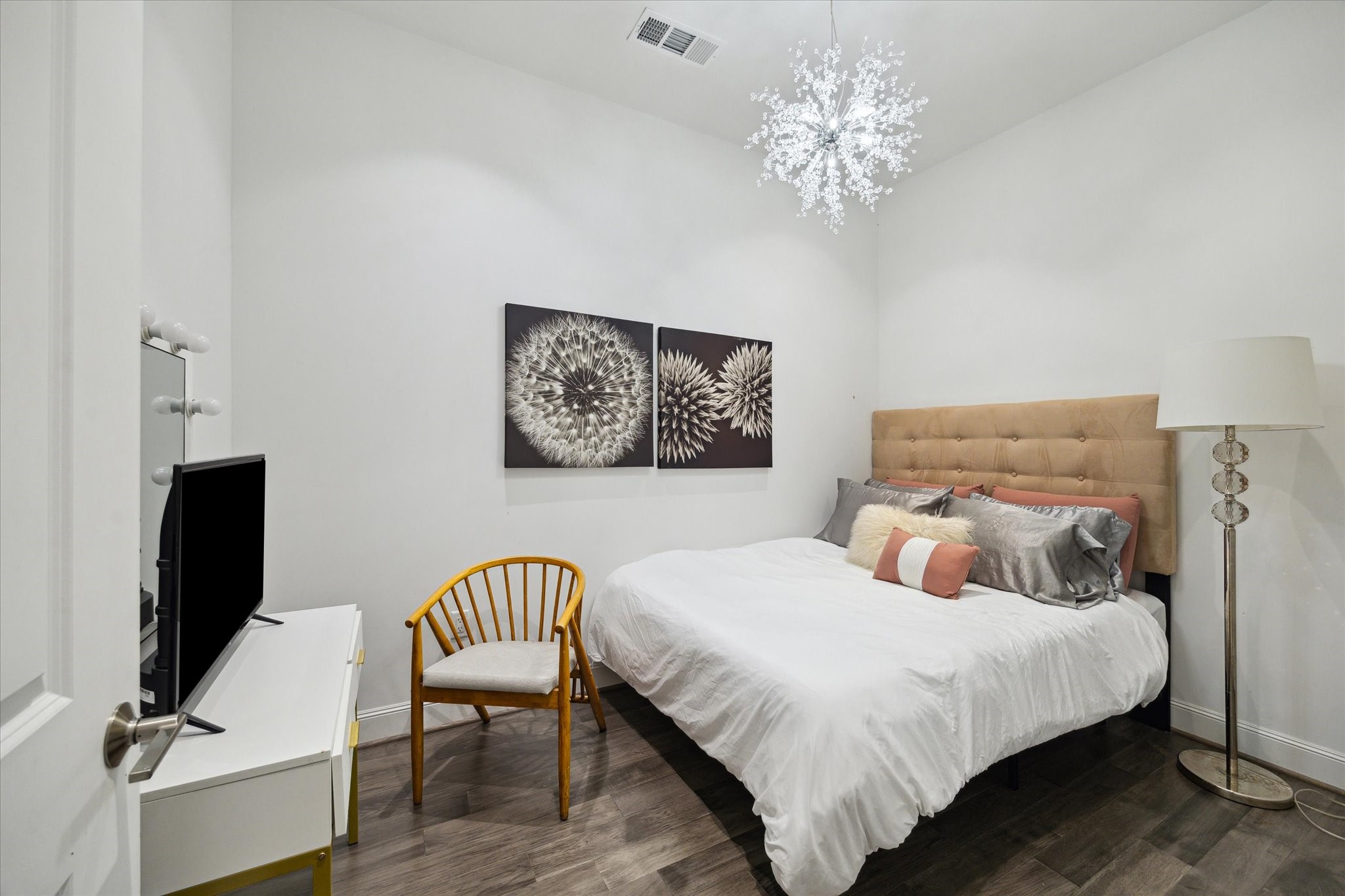 1211 Caroline Street, Unit 1007 Houston, TX 77002 - Photo 14 of 46 a bedroom with a bed and a chandelier