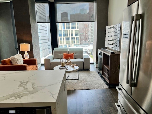 1211 Caroline Street, Unit 1007 Houston, TX 77002 - Photo 7 of 46 a living room with furniture a large window and a refrigerator