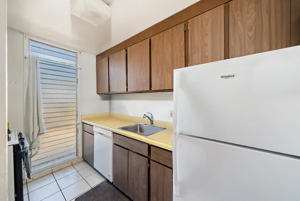 a view of a kitchen with sink and refrigerator