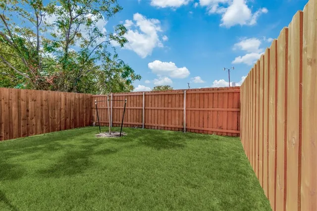 a view of a backyard with wooden fence