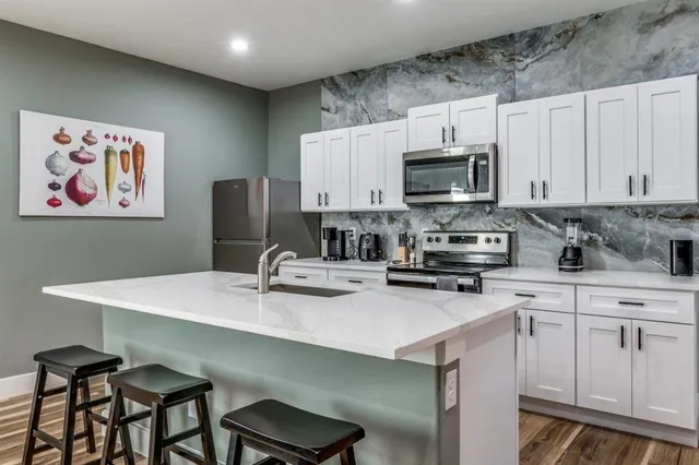 a kitchen with stainless steel appliances a stove refrigerator sink and cabinets