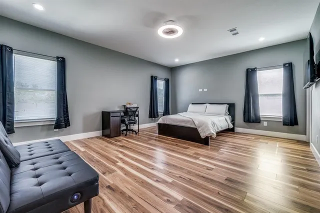 a bedroom with a bed and wooden floor