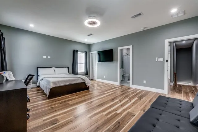 a bedroom with a large bed and a flat screen tv