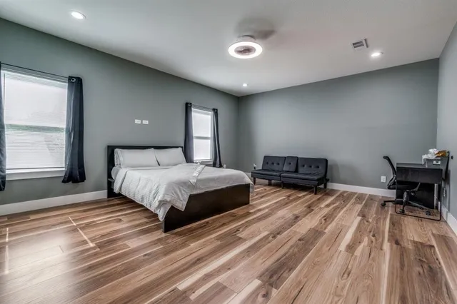 a bedroom with a bed and wooden floor