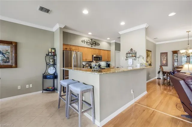 a kitchen with kitchen island a counter top space a sink stainless steel appliances and cabinets
