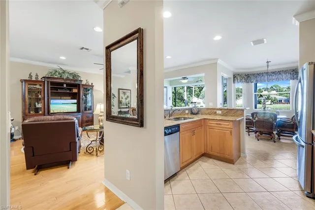 a kitchen with stainless steel appliances kitchen island granite countertop a refrigerator a stove and a sink with granite countertops