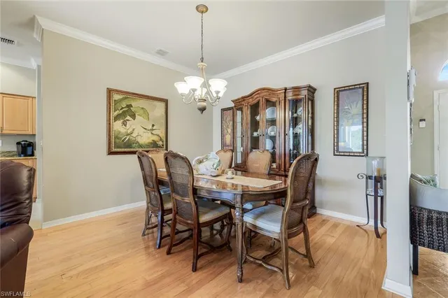 a view of a dining room with furniture a chandelier and wooden floor