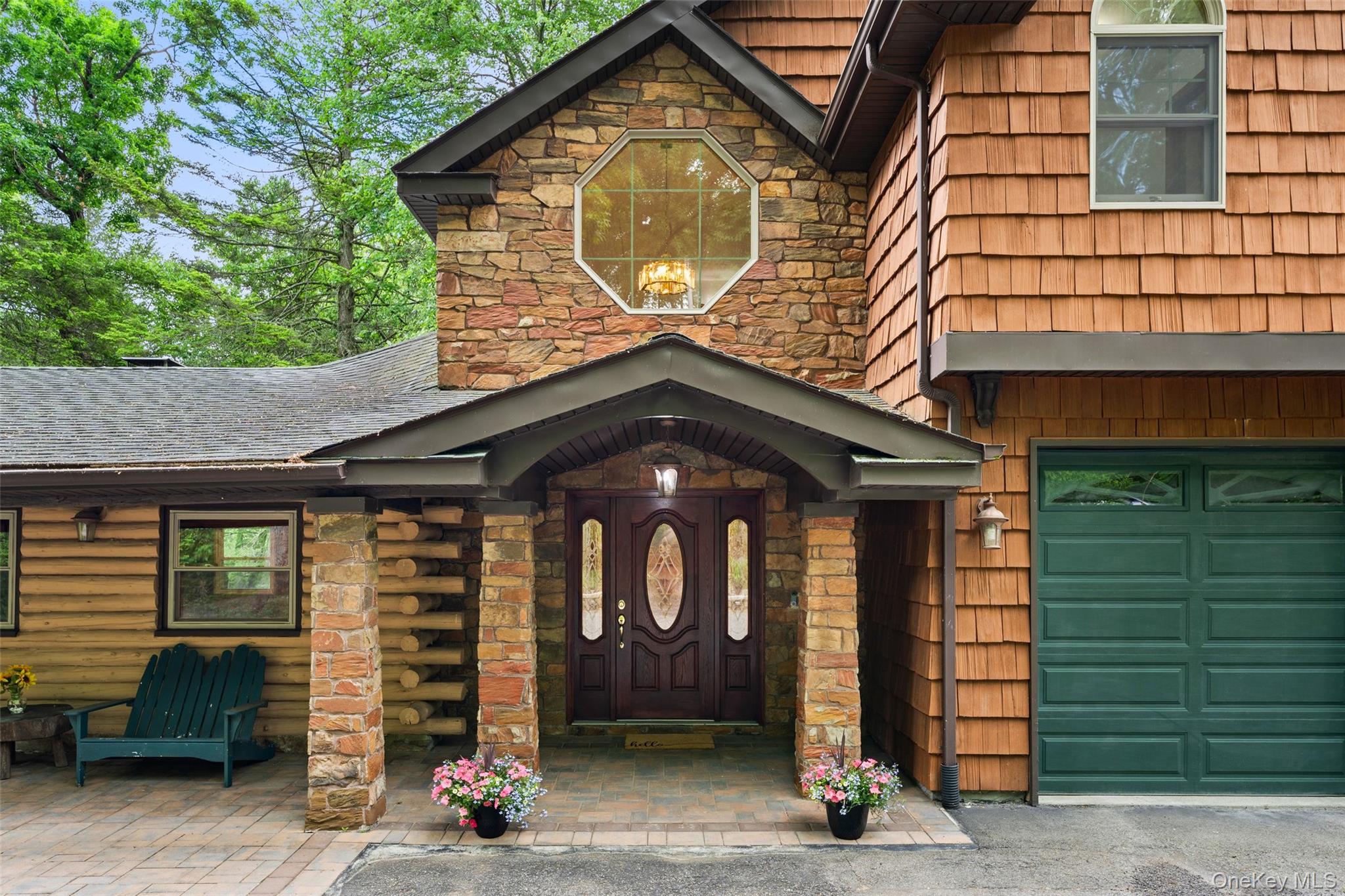 25 Cabin Ridge Road Chappaqua, NY 10514 - Photo 1 of 39 Stone and cedar shake exterior featuring a covered entry, arched dark wood front door with decorative glass, and an octagonal window