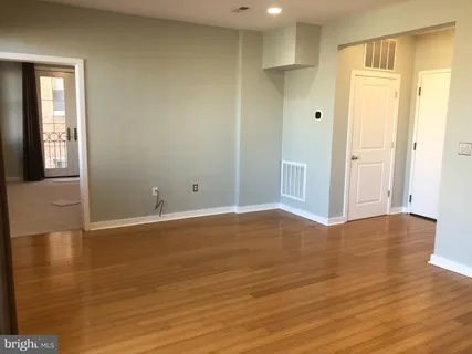 a view of an empty room with wooden floor