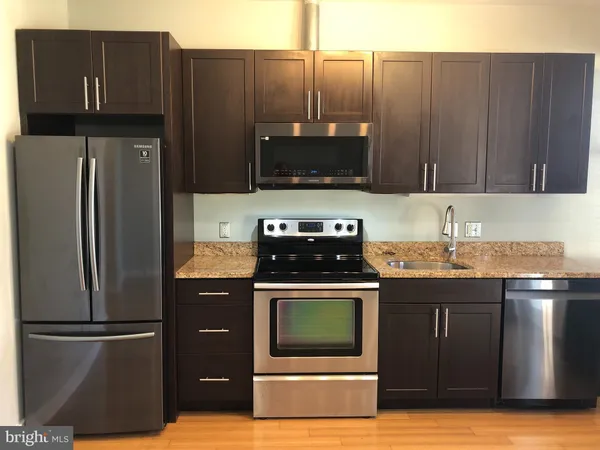 a kitchen with granite countertop a stove and a refrigerator