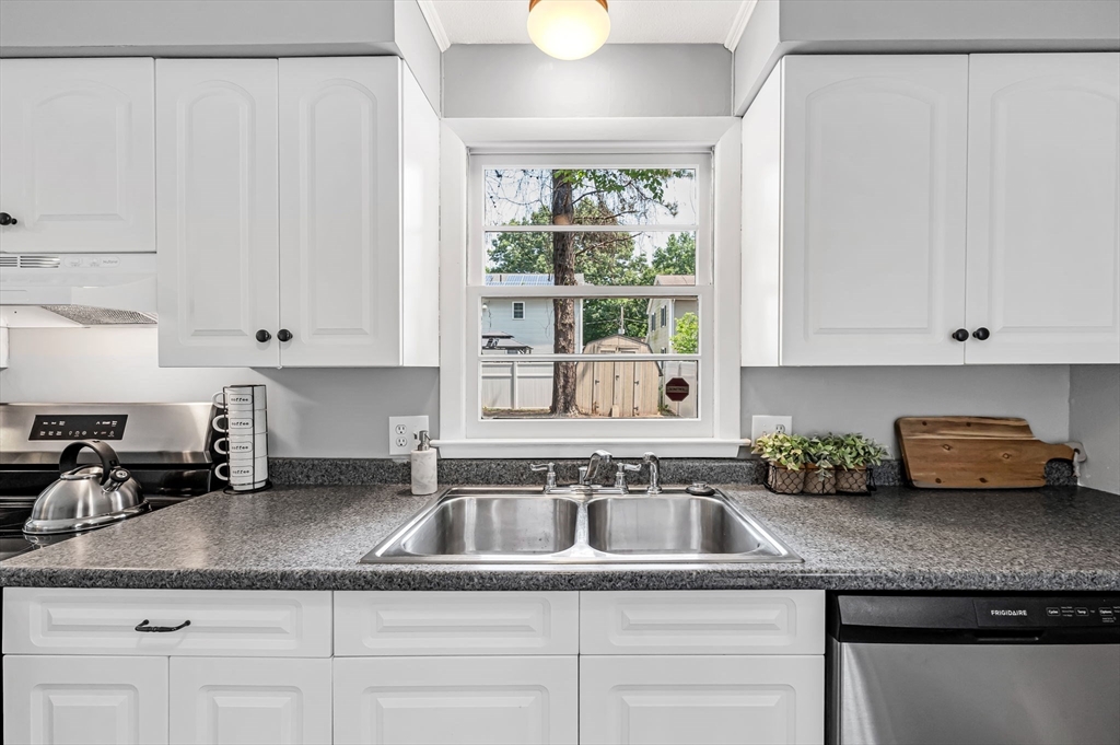 17 Delmore Street Springfield, MA 01109 - Photo 13 of 42 a kitchen with granite countertop a sink a stove and cabinets